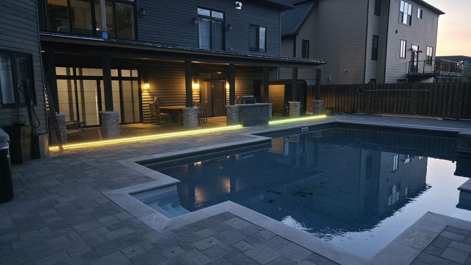 Backyard pool patio and composite deck at dusk